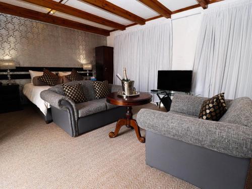 uma sala de estar com dois sofás e uma cama em Casa Blanca Boutique Hotel Pension em Windhoek