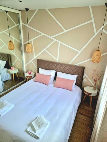 une chambre avec un grand lit blanc avec des oreillers roses dans l'établissement Maison 2/4 personnes, à Josse