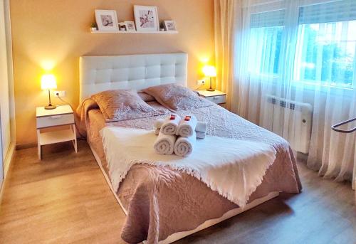 ein Schlafzimmer mit einem Bett mit drei Handtüchern darauf in der Unterkunft Casa en Cortiñan in Bergondo