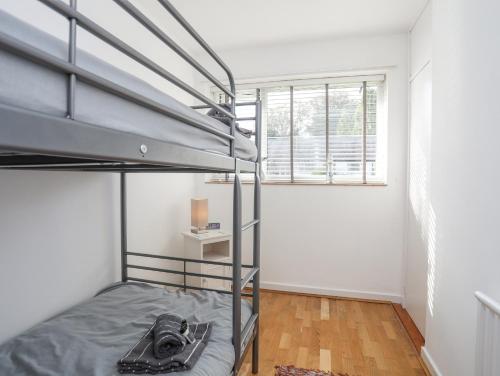 a bedroom with a bunk bed and a window at Ty Cerrig in Pwllheli