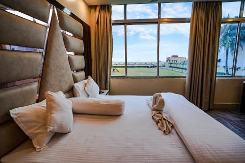 a bedroom with a large bed with a large window at Silver Sand Eco Resort !! Beachfront !! in Mandarmoni