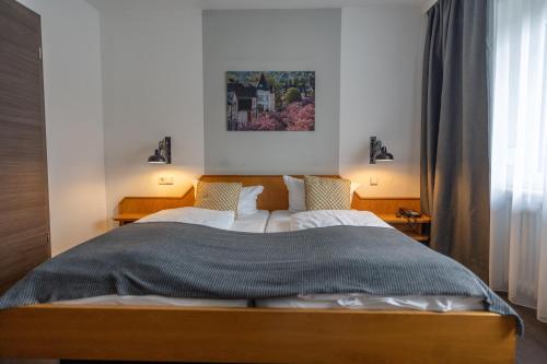 a bedroom with a large bed with two lamps at Hotel Stümpelstal in Marburg an der Lahn