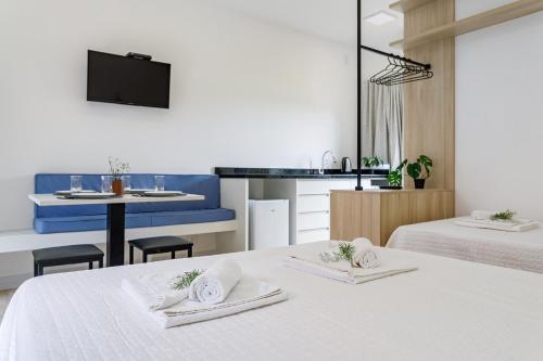 a room with two beds and a kitchen with a table at Elite Hotel in Florianópolis