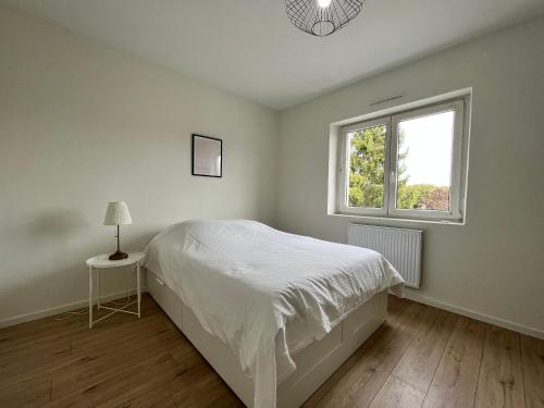 een witte slaapkamer met een bed en een raam bij Lumineux Apt 1BR Type Loft Proche Centre in Thionville