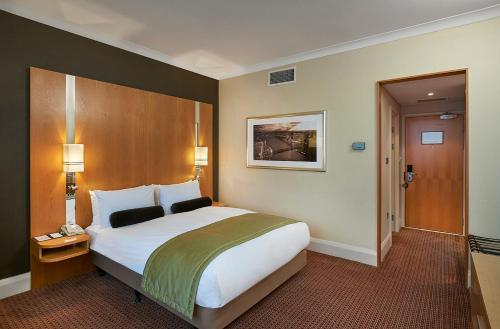 um quarto com uma cama grande num quarto de hotel em Crowne Plaza London Ealing, an IHG Hotel em Londres