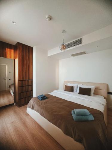 Un dormitorio con una cama grande con una manta marrón. en Prestigio Sea view apart, en Batumi