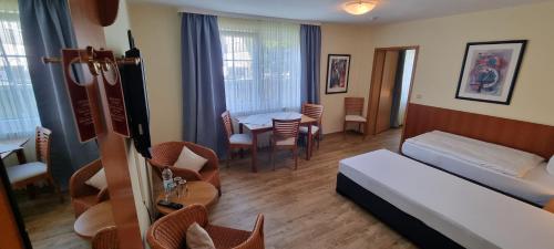 um quarto de hotel com uma cama, uma mesa e cadeiras em Hotel Willinger Mitte em Willingen