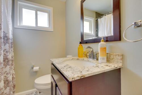 a bathroom with a sink and a mirror and a toilet at Pet-Friendly Ohio Escape with Patio, Near Downtown! in Dayton