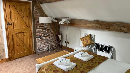 1 dormitorio con 1 cama con toallas en 3 Bedroom Character Peak District Farmhouse Near Alton Towers, Polar Bears, Chatsworth House en Cheadle