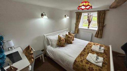 1 dormitorio con cama, escritorio y ventana en 3 Bedroom Character Peak District Farmhouse Near Alton Towers, Polar Bears, Chatsworth House en Cheadle