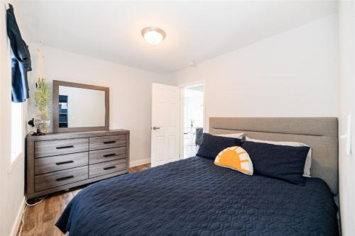 um quarto com uma cama e uma cómoda com um espelho em Blue Caribou Bungalow em Penticton