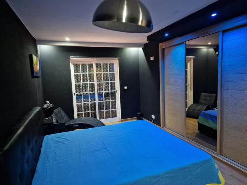 1 dormitorio con cama azul y espejo en Romantic room in house with pool en Seixal