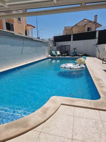 una gran piscina con fideos en el medio en Romantic room in house with pool en Seixal