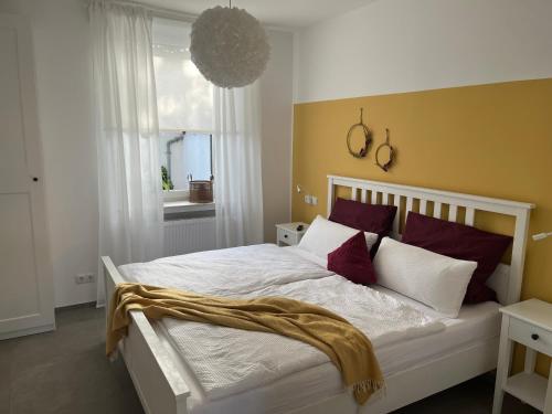1 dormitorio con 1 cama grande con almohadas rojas y blancas en Ferienwohnung Basaltliebe Mendig, en Mendig