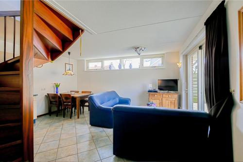 sala de estar con silla azul y mesa en Vakantiehuis Guja - Callantsoog en Callantsoog