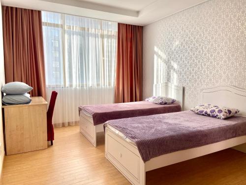 a hotel room with two beds and a window at Хайвилл Астана in Astana