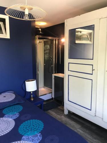 a room with a bed and a door to a shower at VILLA LES TERRASSES dans la nature avec piscine à 2 pas de Lyon, in Oullins