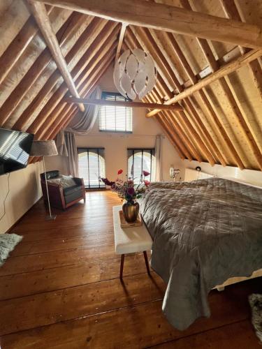Un dormitorio con una cama grande en una habitación con techos de madera. en La Dolce Vita Suites, en Leeuwarden