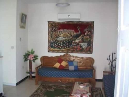 a living room with a couch and a painting on the wall at Diar Karim Djerba in Midoun