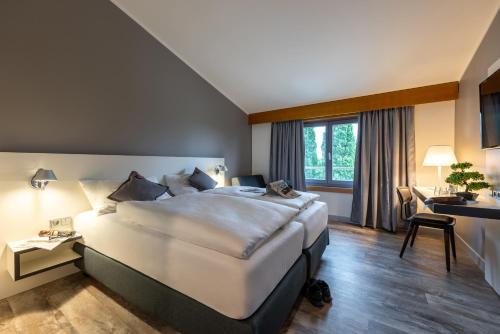 een hotelkamer met een groot bed en een bureau bij Hotel Leipheim Süd in Leipheim
