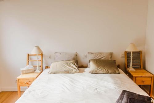 a bedroom with a large white bed with two night stands at ScraB&Ble Ecologische gastenkamers in Bornem