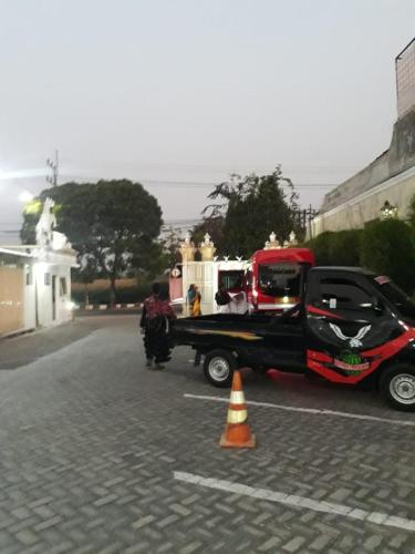 a tow truck with a car on the back of it at Votel Hotel De'Pratnya Kediri in Kediri