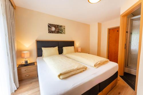 a bedroom with a large bed with white sheets at Gästehaus -Pension Edelweiss in Vent