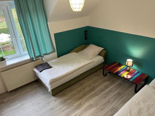 Dormitorio pequeño con cama y mesa en Zajazd Magrani, en Lubawka