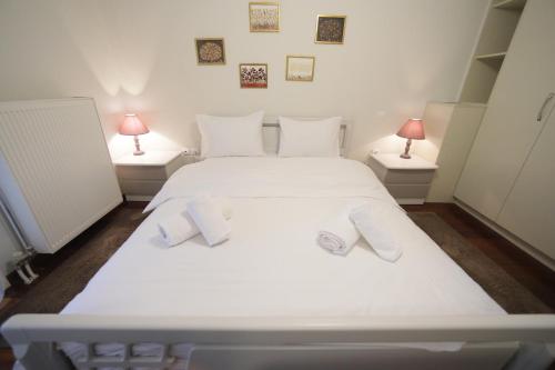 een slaapkamer met een wit bed en handdoeken bij LIDA'S APARTMENT LAKE VIEW in Kastoria
