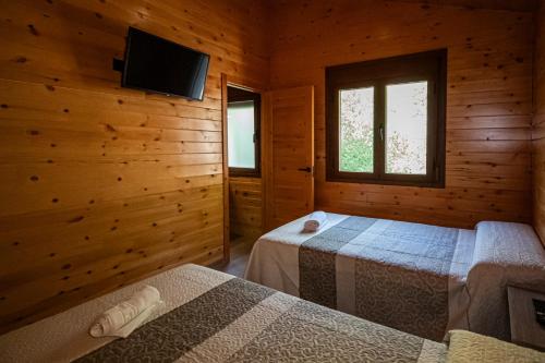 Dormitorio con 2 camas y cabina con TV en Apartamentos 7 puentes sierra Cazorla, en Burunchel