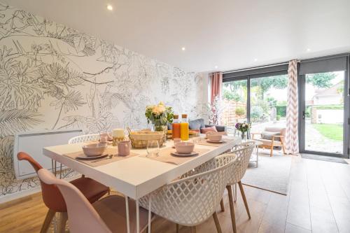 une salle à manger avec une table et des chaises dans l'établissement Maison Macaron 10min Disneyland Paris, à Bailly-Romainvilliers