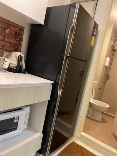 a black refrigerator in a kitchen with a toilet at Baan Peang Ploen Hua Hin 6/546 in Hua Hin