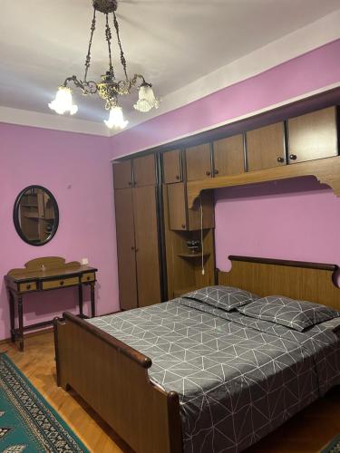 um quarto com uma cama e uma parede rosa em Mtatsminda Apartment Best View em Tbilisi
