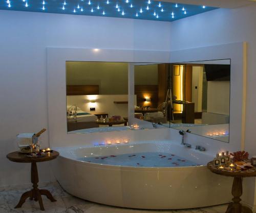 uma grande banheira num quarto com um espelho em Hotel Luna Lido em Torre San Giovanni Ugento
