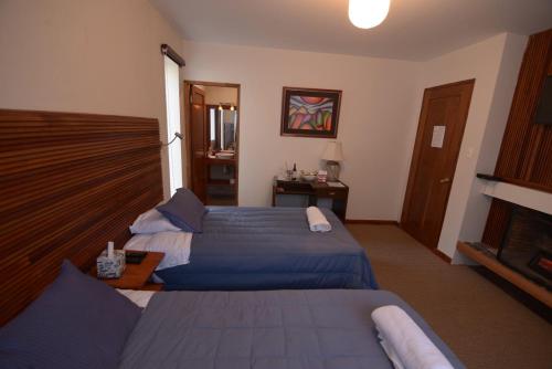 a hotel room with two beds and a fireplace at Hotel Mia Inn in La Paz