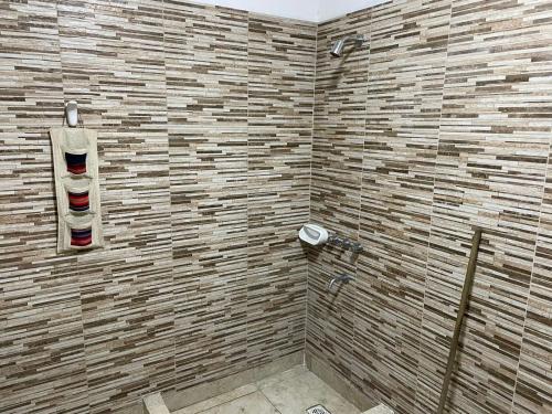 een badkamer met een douche en een bakstenen muur bij el mistol in San Miguel de Tucumán