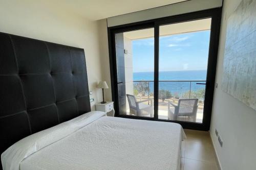 a bedroom with a bed and a view of the ocean at Luxury Apartment/ Sea views/Pool/Gym in San Jorge