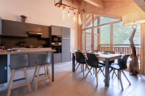 une cuisine avec une table et des chaises ainsi qu'une salle à manger dans l'établissement Terra Losa 2 - Quiet and modern apartment - City center, aux Houches