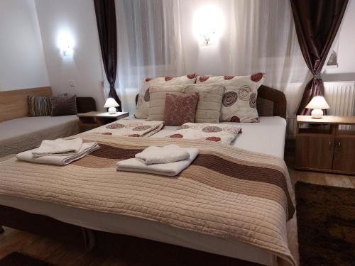 a bedroom with a large bed with towels on it at Tulipán Vendégház in Sárospatak