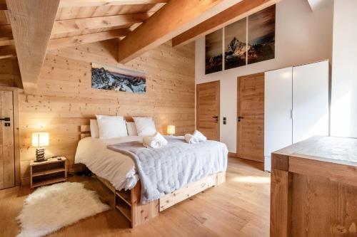 ein Schlafzimmer mit einem Bett und einer Holzwand in der Unterkunft Terra Losa 2 - Quiet and modern apartment - City center in Les Houches