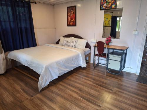sypialnia z łóżkiem, biurkiem i stołem w obiekcie Pepper county farm stay w mieście Munnar