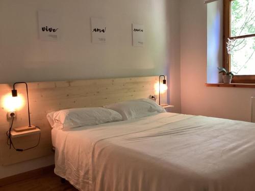 1 dormitorio con 1 cama blanca y 2 lámparas en P06 Dellui By Immovall, en Pla de l'Ermita