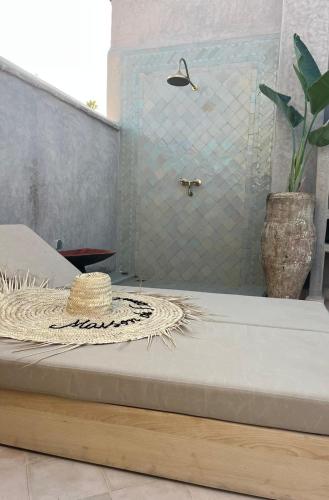 a straw hat sitting on a bed in a bathroom at Riad des Fragrances dar el Bacha in Marrakech