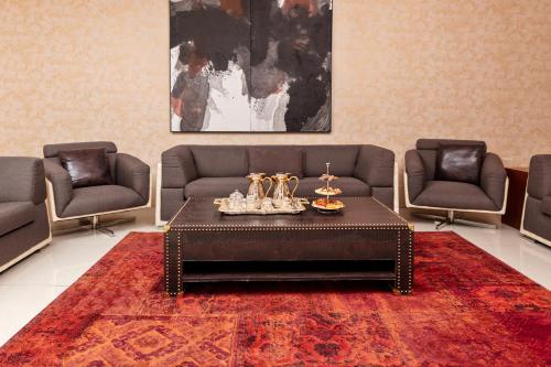 a living room with a couch and a table and chairs at M Hotel Makkah by Millennium in Makkah