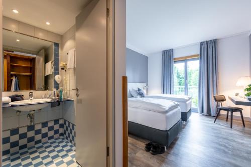 Cette chambre comprend un lit et un lavabo. dans l'établissement Hotel Leipheim Süd, à Leipheim