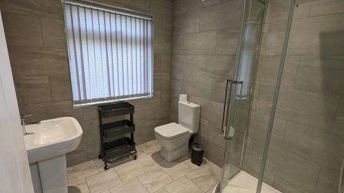 e bagno con servizi igienici, lavandino e doccia. di Modernised 4 Bedroom Property Close To City Centre, Harehills Lane a Roundhay