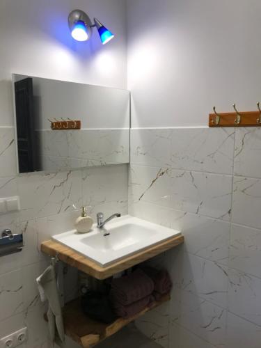 un bagno bianco con lavandino e specchio di Baņuta_2 a Saulkrasti
