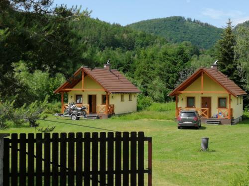 duas casas rústicas com um carro estacionado à frente delas em Domki BIOSEN em Podgórzyn