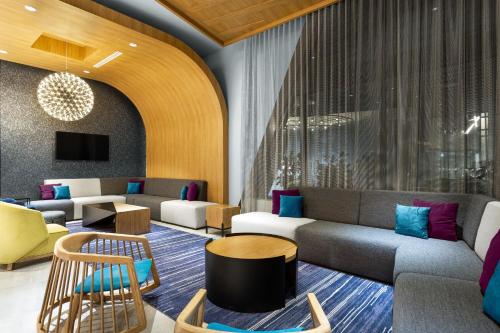 a lobby with a couch and chairs and a table at Aloft San Juan in San Juan
