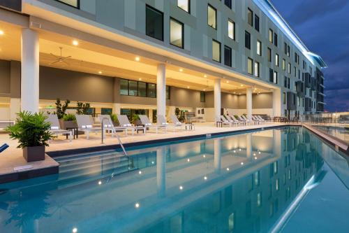 a hotel swimming pool in front of a building at Aloft San Juan in San Juan